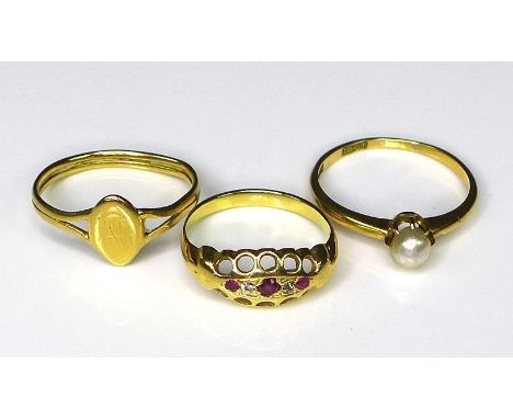 A group of three 18ct gold rings, comprising a ring set with rubies and diamond chips in a scalloped setting, size H/J, a rin