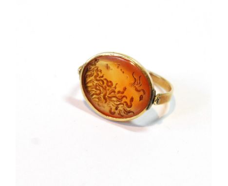 Antique ring with carnelian intaglio head of Medusa in oval bezel swivelling upon slender gold band, the mount probably late 