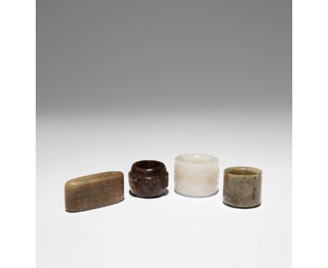 THREE CHINESE ARCHERS' RINGS AND A JADE SWORD SLIDE QING DYNASTY AND LATER The largest ring carved in white jade with a sinuo