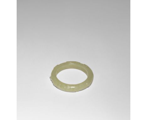 A CHINESE YELLOW JADE BANGLE QING DYNASTY OR LATER Carved with two kui dragons on a geometric ground, 7cm.