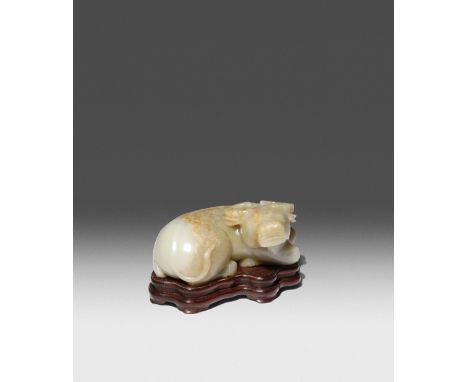 A CHINESE CELADON JADE RECUMBENT BUFFALO QING DYNASTY OR LATER Naturalistically carved to depict the animal resting with its 