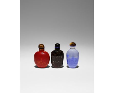 THREE CHINESE SNUFF BOTTLES 19TH/ 20TH CENTURY Two in glass with red and brown mottled bodies, the third ceramic decorated wi