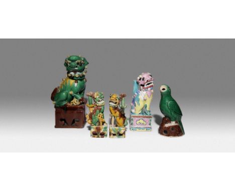 FOUR CHINESE FIGURES OF LION DOGS AND A MODEL OF A PARROT 18TH AND 19TH CENTURY Variously decorated with sancai glazes and fa