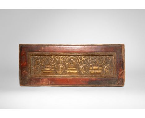 A TIBETAN CARVED GILT-WOOD MANUSCRIPT COVER 14TH/15TH CENTURY Decorated with three figures, probably artisans, standing upon 