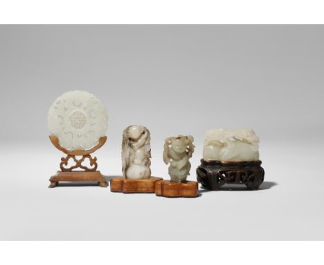 FOUR SMALL CHINESE JADE CARVINGS QING DYNASTY Comprising: a pale celadon carving of two recumbent animals grasping branches o