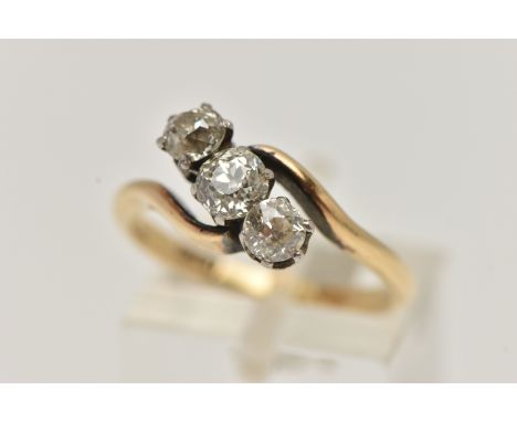 A YELLOW METAL THREE STONE DIAMOND RING, cross over design, set with three old cut diamonds, estimated total diamond weight 0