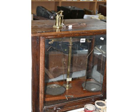 A SET OF BALANCE SCALES, housed in a glazed oak case, approximate height of case 52cm, together with a brass cartridge loadin