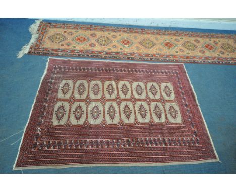 A RED GROUND WOOLEN TEKKE RUG, with sixteen medallions and a multi strap border, 182cm x 128cm, along with a woollen patterne