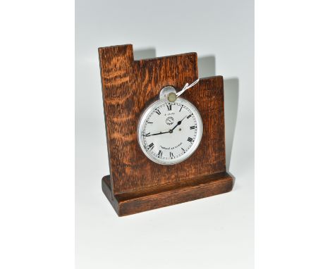 A JAEGER FOUR DAY CAR CLOCK, fitted into an oak mount, the silver coloured dial having Roman numeral hour markers, marked Jae