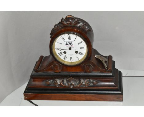 A VICTORIAN ROSEWOOD AND EBONISED CASED MANTEL CLOCK, the drum shaped clock case with foliate surmount, white enamel dial wit