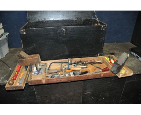 A WOODEN CARPENTERS TOOLBOX CONTAINING TOOLS including saws, shoulder and hand braces, two wooden coffin planes, mallets, bev