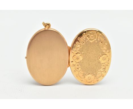 A YELLOW METAL OVAL LOCKET, floral pattern to the front, opens to reveal two vacant photo compartments, fitted with a tapered