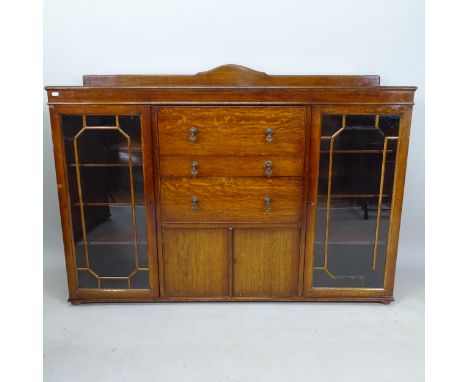 A 1920s oak side cabinet, with central drawers and cupboards flanked by lattice-glazed doors, 150cm x 100cm x 44cm 