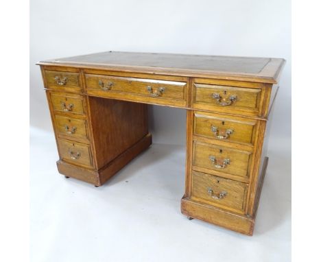 An early 20th century oak pedestal desk, with 9 fitted drawers and leather skiver, 122cm x 75cm x 64cm, kneehole 55cm x 58cm