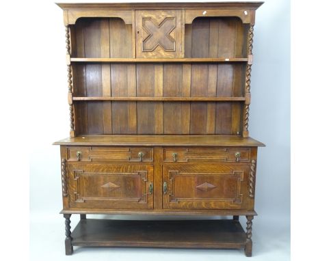 A 1920s oak 2-section dresser, having a boarded open plate rack with cupboard above, 2 frieze drawers, cupboards and pot boar