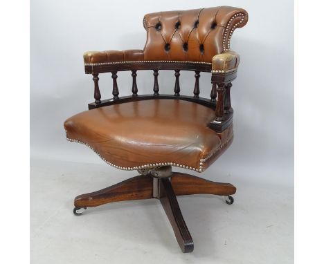 A studded and button-back brown leather bow-arm swivel office chair 