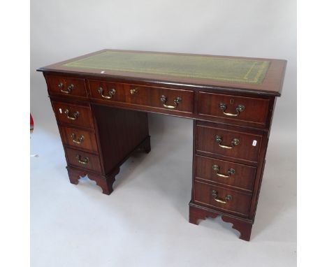 A reproduction mahogany pedestal writing desk, with tooled and embossed green leather skiver, and 9 fitted drawers, 122cm x 8
