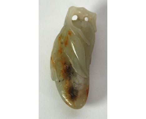 A CHINESE QING DYNASTY CELADON JADE CARVING with russet inclusions in the form of a pumpkin issuing from a leafy tendril hole