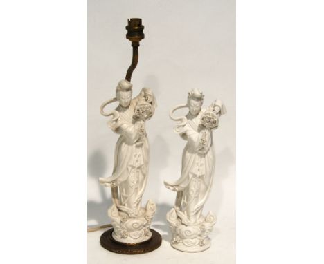 PAIR OF CHINESE BLANC DE CHINE FIGURES OF GUAN YIN, modelled in long flowing robes, holding a basket of flowers and raised on