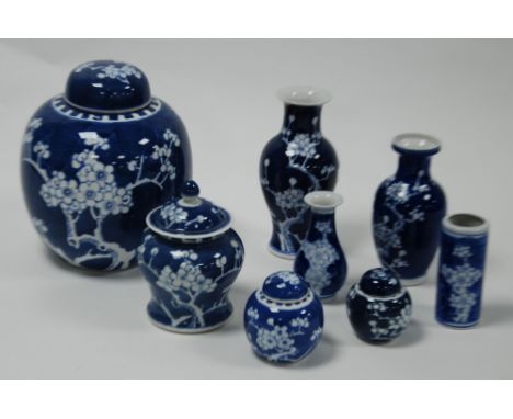 FOUR MODERN CHINESE BLUE AND WHITE PORCELAIN FINGER JARS AND COVERS AND FOUR SIMILAR VASES, all decorated in the prunus on a 