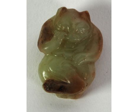 CHINESE QING DYNASTY TINY CELADON JADE CARVING with russet inclusions of a bear, pierced through for suspension, 1 1/4" (3cm)