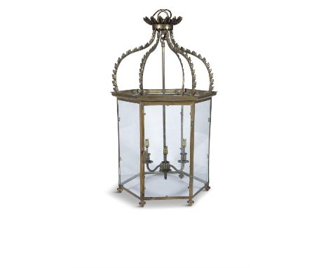 AN EDWARDIAN BRASS FRAMED HEXAGONAL HALL LANTERNWith clear glass panel sides, and scroll arms leading to a leaf cast corona a