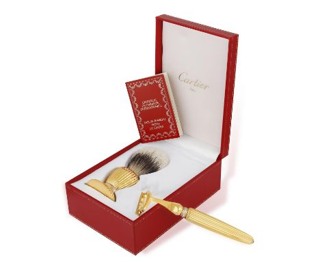 A 'PASHA' RAZOR AND BARBER BRUSH, BY CARTIER, the razor with fluted handle, trinity ring and blue cabochon terminal decoratio