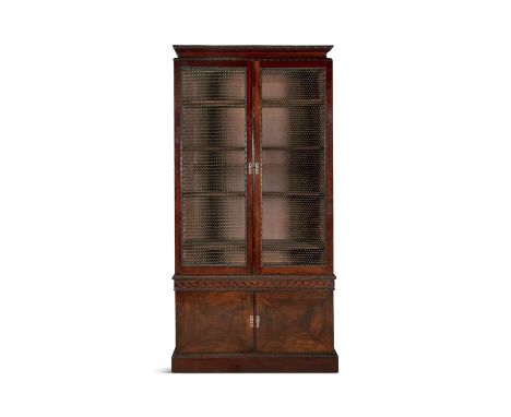 A GEORGE IV MAHOGANY TALL BOOKCASEThe inverted moulded cornice above twin wire grill bookcase drawers on a twin panel door ca