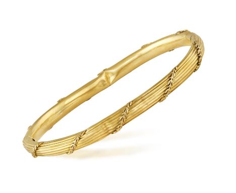 A GOLD BRACELET, the hinged bracelet with reeded detailing throughout with foliate decorations, mounted in 18K gold, with mak