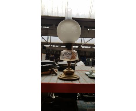 A brass based oil lamp with funnel and glas shade 