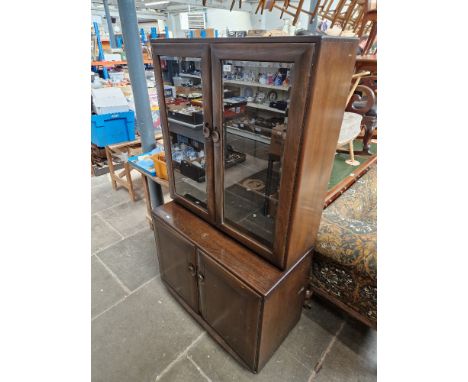 An Ercol dark elm glazed cabinet 