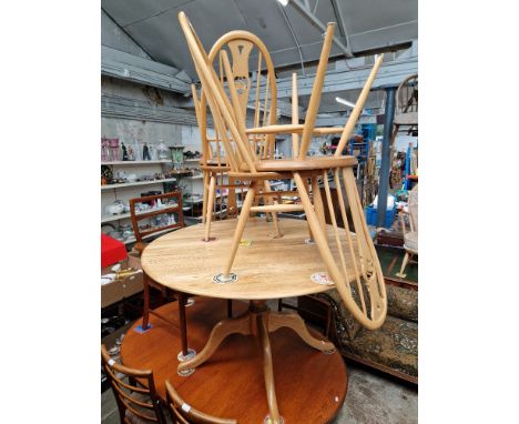 A modern Ercol light elm dining table and four swan back chairs, height 72cm and diameter 120cm. 