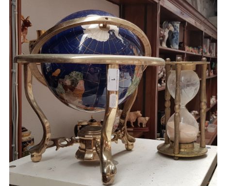 A gemstone terrestrial globe on brass stand and a brass sand timer. 