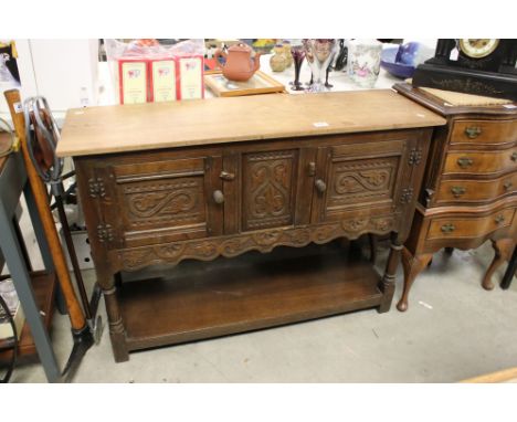 20th century Oak Side Cabinet in the 17th century manner with two carved cupboard doors and an under-shelf, 107cms long x 76c