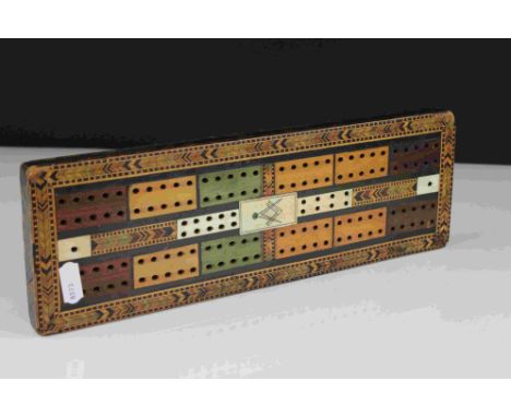 A vintage decorative cribbage board with masonic marks to centre. 