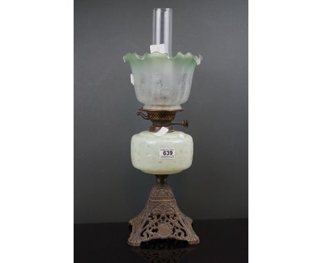 An antique early 20th century oil lamp with pierced metal base, light green well &amp; shade with floral decoration. 