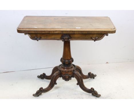 19th century Rosewood Fold-over Card Table with green baise playing surface raised on a carved turned pedestal and four carve