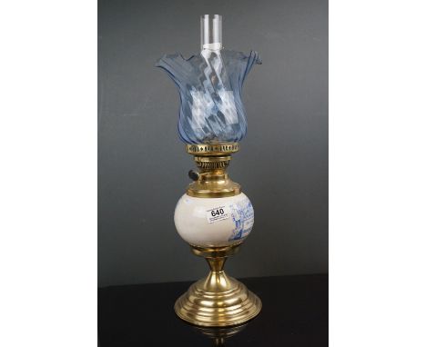 An Edwardian brass oil lamp with advertising, Solon Caddy's Fine Groceries, with blue scrolling shade. 