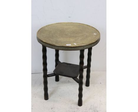 Indian / South East Asian Circular Brass Top Table raised on bobbin style supports, 69cms high 