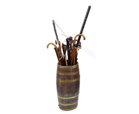 OAK STICK STAND & WALKING STICKS an oak barrel stick stand containing a variety of walking sticks, umbrellas etc. Including a