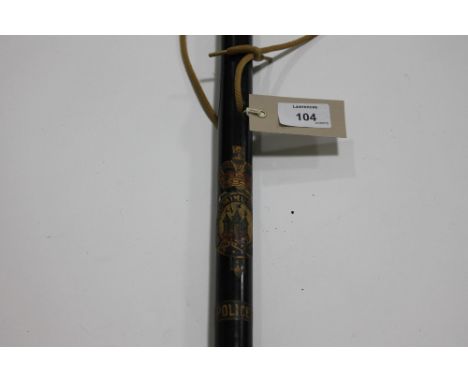 A MOUNTED POLICE OFFICERS BATON. A black painted baton stick of a mounted city police officer. 23.3/4" long with painted cres