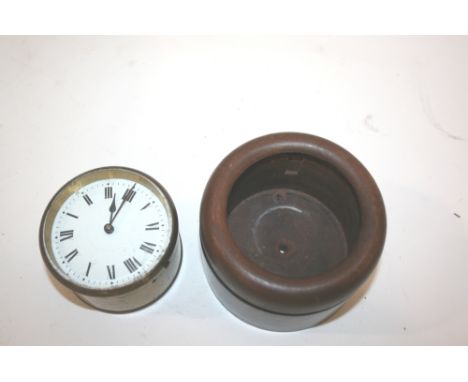 CAR CLOCK an interesting brass cased clock, with an enamel dial and French movement. In a wooden case, with two holes from wh