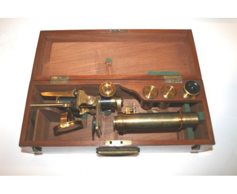 CASED BRASS MICROSCOPE an interesting brass monocular microscope, on a brass folding tripod stand and in a fitted mahogany bo