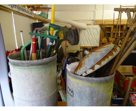 Two metal wastebins with quantity of long handled garden tools including strimmer E/T