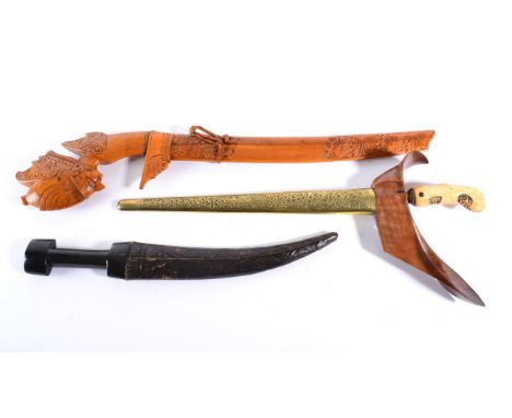 A Javanese Kris, with 35cm eleven lok pamor blade, gilt metal mendak set with glass stones, with carved light wood grip, the 