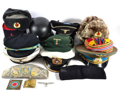 A Quantity of Military Hats, including a Russian Air Force officer's peaked cap, a copy of an SS officer's peaked cap, a copy