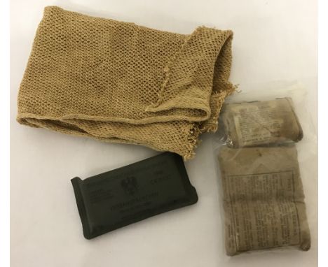 A Gulf War neck veil together with 4 army first aid dressings.3 British army field dressings c1929, a German field dressing d