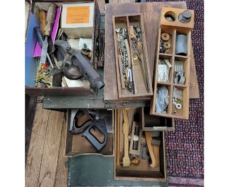 A collection of vintage and antique tools housed in a metal box with drawers, also including tools within a leather breifcase
