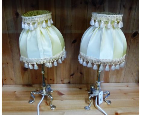 A pair of brass table lamp bases complete with yellow silk shades (2) 