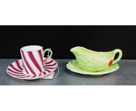 A continental porcelain claret and white glazed cabinet cup and saucer together with a small Carlton ware leaf moulded sauce 